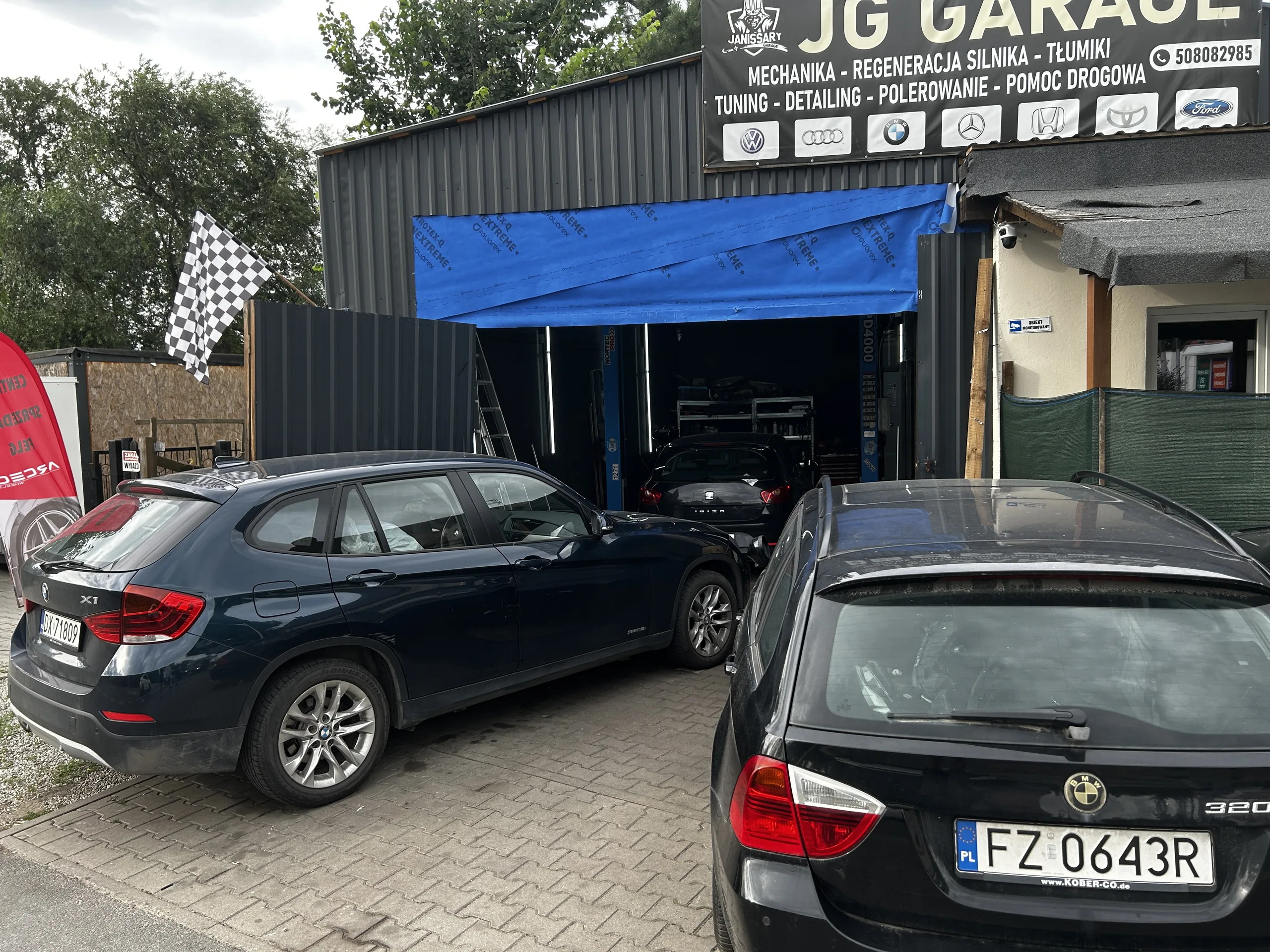 Warsztat samochodowy Janissary Garage we Wrocławiu - wejście i tablica usług